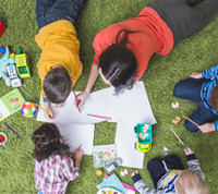 Enfants allongés sur herbe dessinant